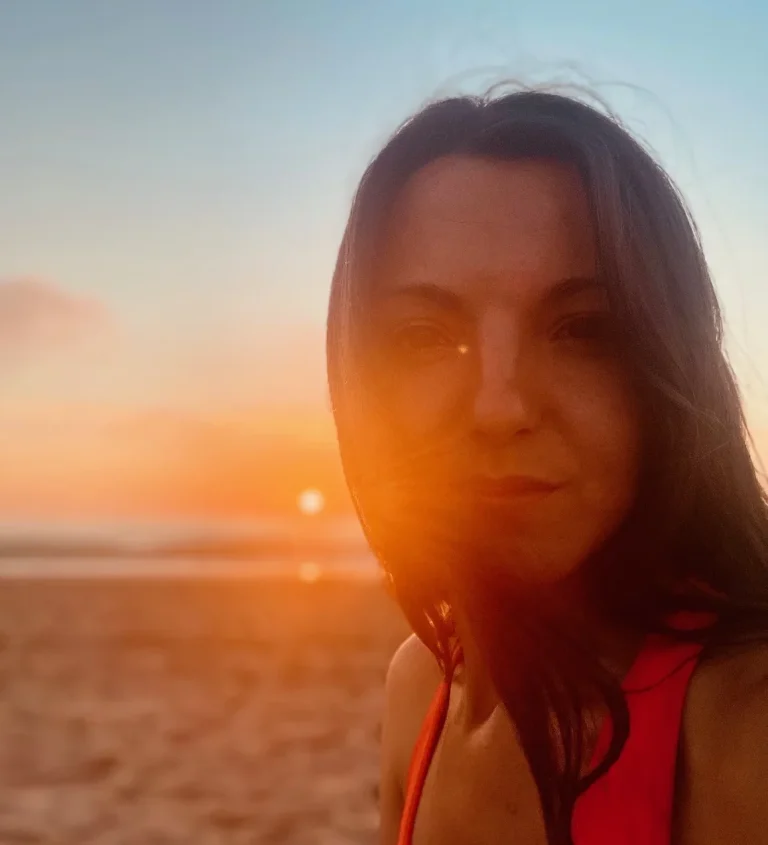Porträt einer jungen Frau im warmen Sonnenuntergangslicht am Meer